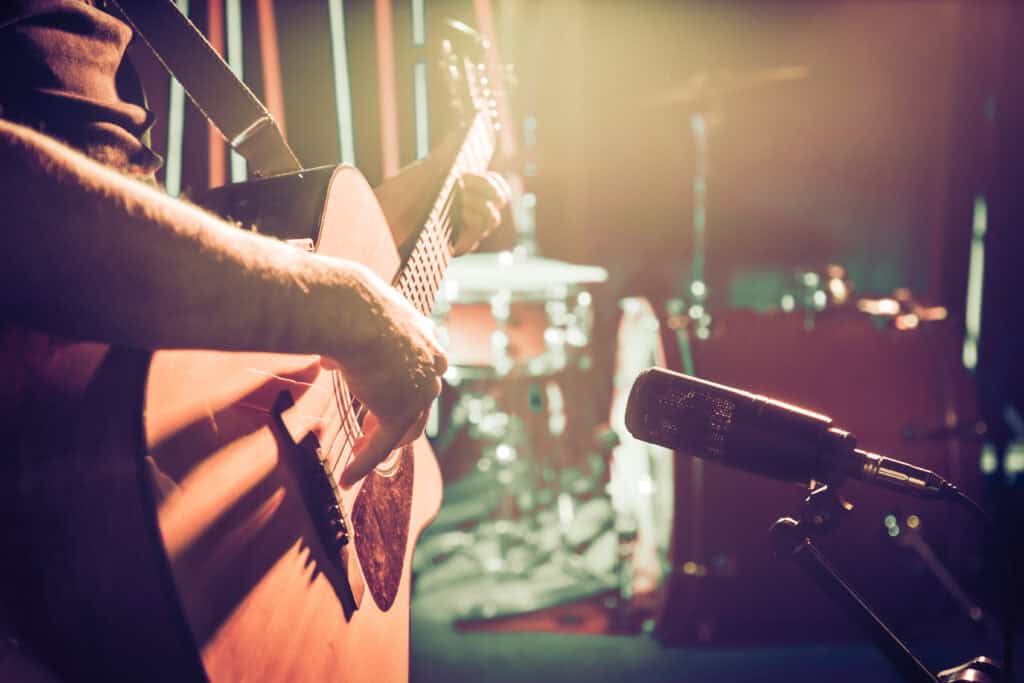 Musician playing guitar on stage